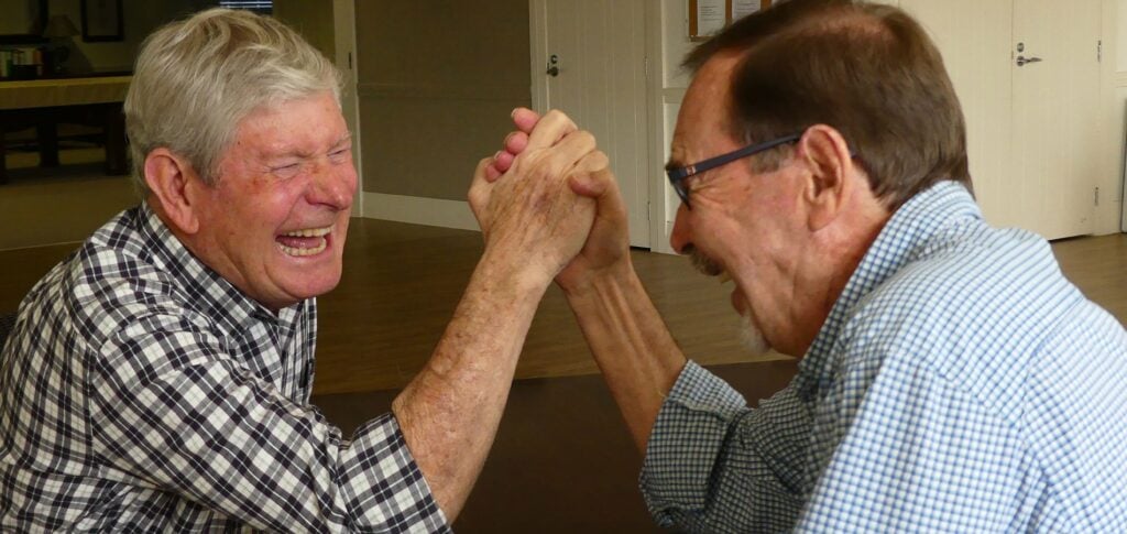 high end senior living community enjoying a game of arm wrestling