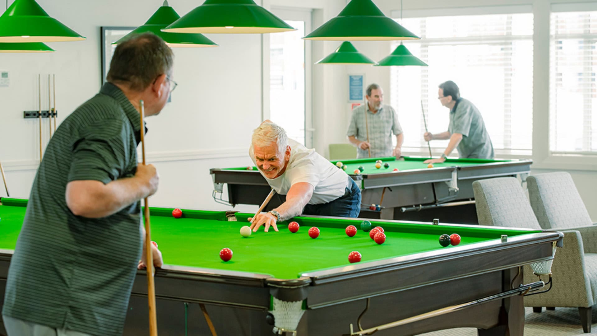 Residents playing billiards and socialising in the community recreation area at Settlers Lifestyle Village.