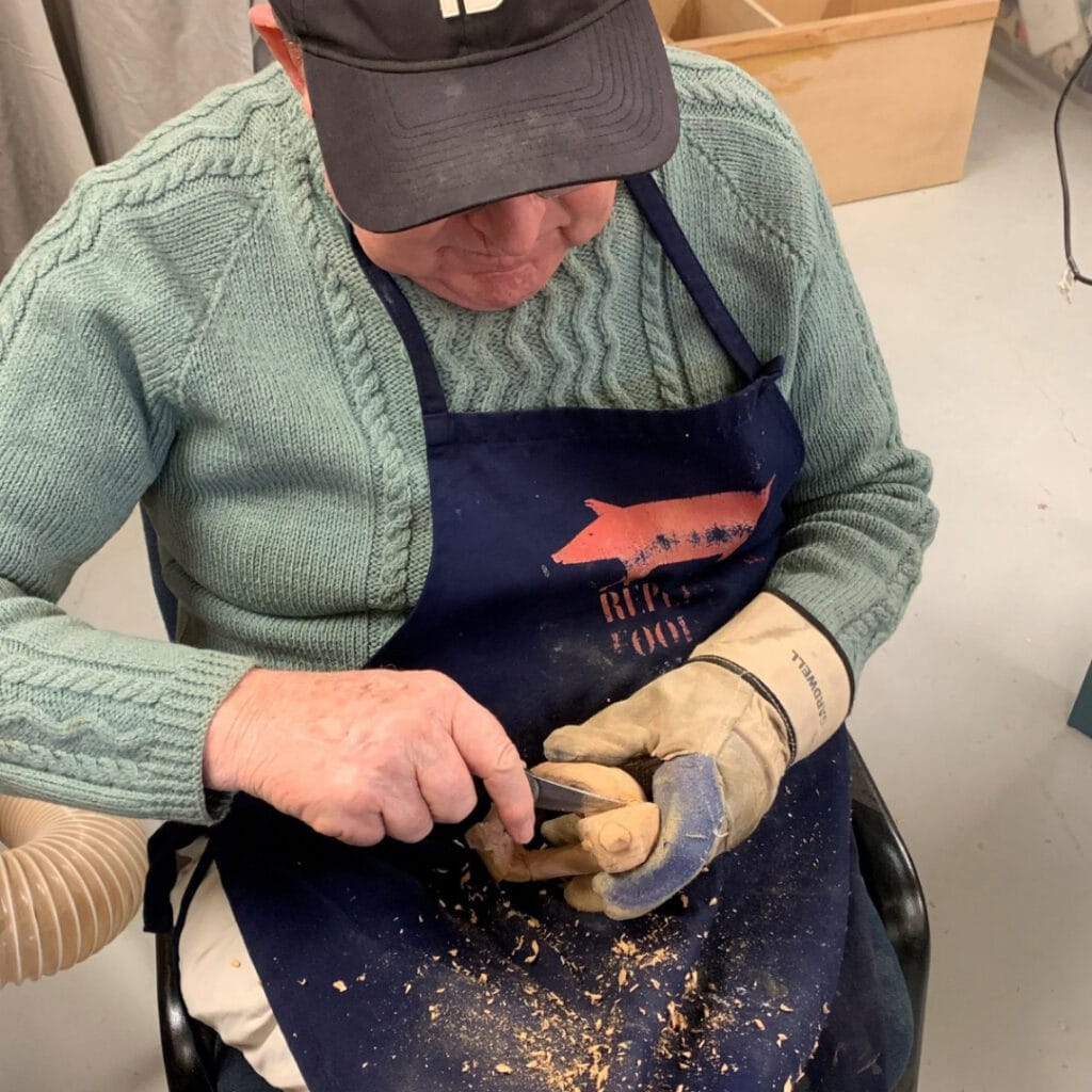 Resident participating in a wood carving workshop as part of the lifestyle and hobby activities available at Settlers Lifestyle Village.