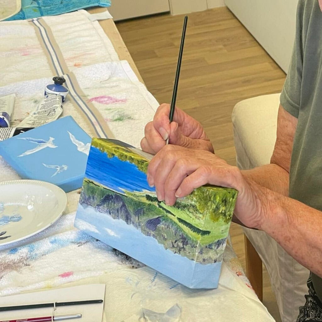 Resident enjoying a painting session and creating artwork during a creative activity at Settlers Lifestyle Village.
