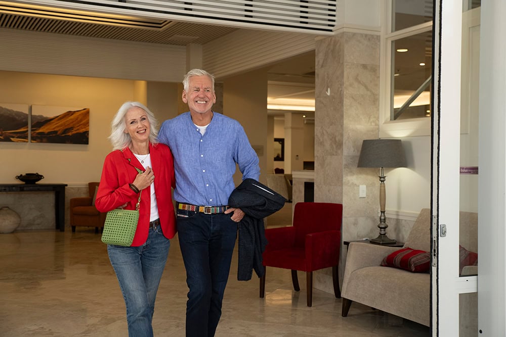 Smiling retired couple walking through a Settlers retirement village